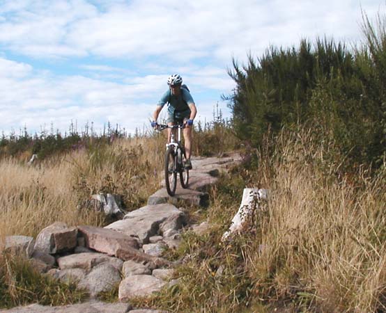 Front view of me riding over section of chunky boulders.