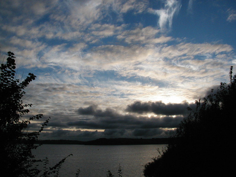 Shot of sky, sun just setting, clusters of small clouds.