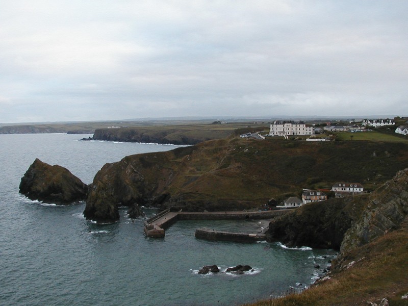 Large grassy headland with tiny harbour down below