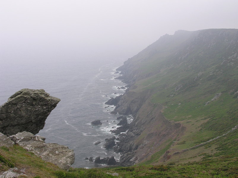 Misty view along rugged rocky coastline.